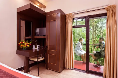 St. George Home Stay private room interior with wooden vanity wardrobe, television, and private forest balcony door